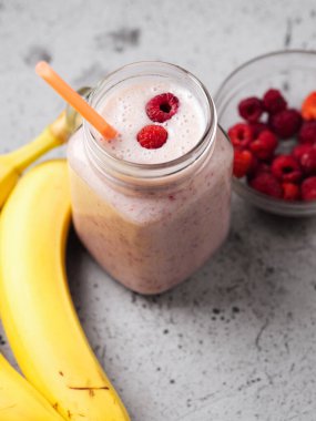 Ahududu ve muzlu bir kavanoz lezzetli yaz meyveli smoothie.