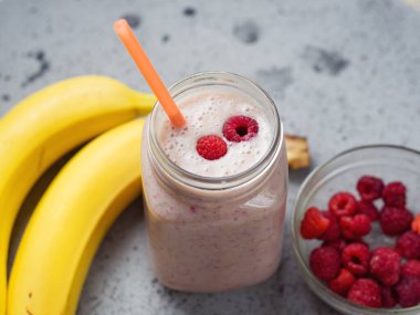 Ahududu ve muzlu bir kavanoz lezzetli yaz meyveli smoothie.