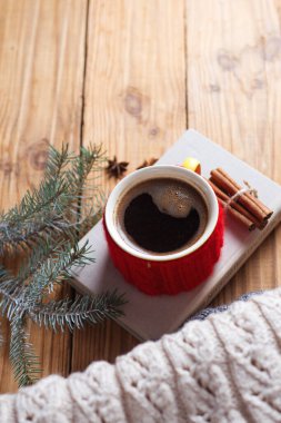 Kışın sıcak örülmüş kazaklı kahve fincanı ve ahşap masada fotokopi alanı.