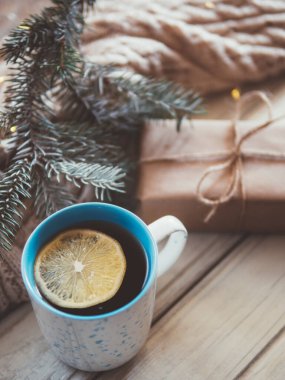 Ahşap bir masada sıcak çay ve limonlu kupa. Kış bileşimi