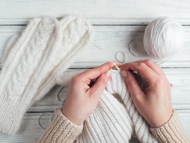 Kadın kışlık kalın giysiler örüyor.