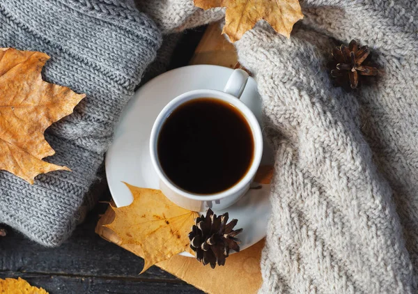 暖かいニットの秋の服でテーブルの上に熱いコーヒーのカップトップビュー — ストック写真