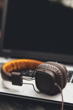 Kulaklıklar masaüstünde dizüstü bilgisayarın yanında.