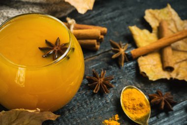 Tahta arka planda süt ve baharatlı zerdeçal çayı