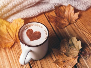 Bir kupa sıcak cappuccino kahve ve bir kalp tarçın. Sonbahar mevsimsel arkaplanı