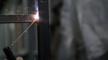 Kaynakçı çalışıyor. Çitin metal çerçevesinin kaynaklanması