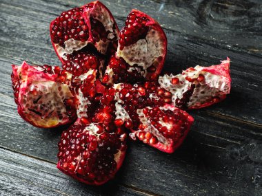 Siyah ahşap bir masada olgun kırmızı nar.