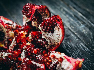 Siyah ahşap bir masada olgun kırmızı nar.