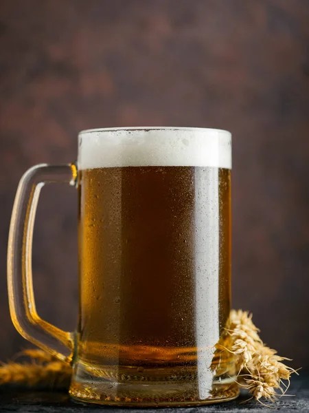 Close-up of a mug of light wheat beer on a dark background