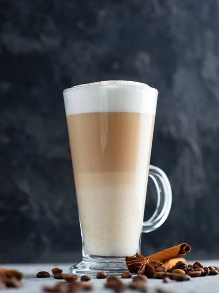 a glass of latte coffee on a concrete table