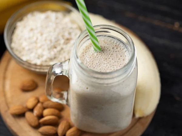 Smoothie Banana Fresco Uma Mesa Madeira Jarro Com Aveia Amêndoas — Fotografia de Stock