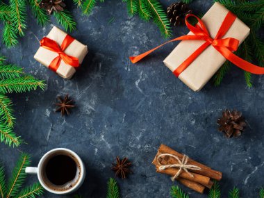 Koyu taş bir masanın üzerinde bir kupa mis kokulu kahve içinde hediye kutuları ve ladin dalları var. Tatil sabahı hediyeler kopyalama alanı