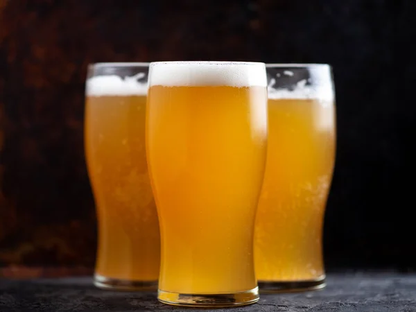 Tre Bicchieri Birra Leggera Non Filtrata Vicino Uno Sfondo Scuro — Foto Stock
