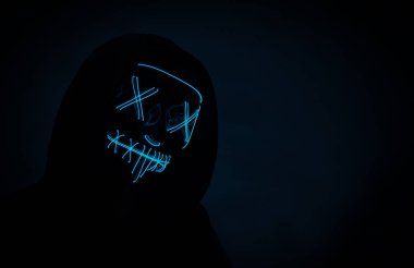 Neon maskeli, cadılar bayramı maskeli isimsiz bir hacker portresi.