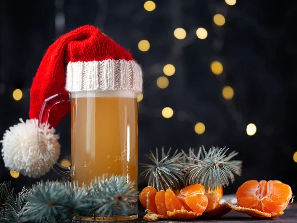 Noel Baba şapkalı bir kupa Turunçgil birası. Arka planda Bokeh çelenkleri var.