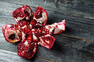 Koyu, ahşap bir masada olgun bir nar.