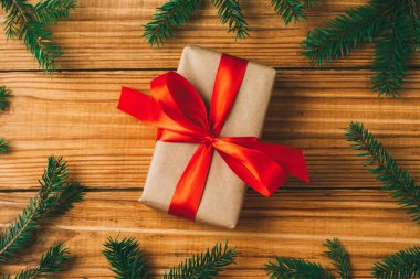 Noel hediyesi ahşap bir arka planda sonsuza dek yeşil bir ağacın dalları arasında