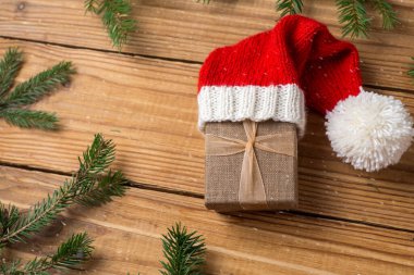 Noel hediyesi ahşap bir arka planda sonsuza dek yeşil bir ağacın dalları arasında