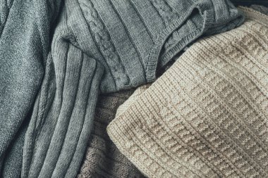 Sıcak örülmüş süveterlerin arka planı. Bir sürü renkli kazak.