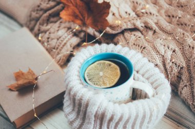 Sıcak bir süveterin yanında bir fincan sıcak çay.