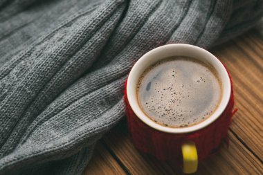 Masada sıcak bir süveter ve bir fincan sıcak kahve.