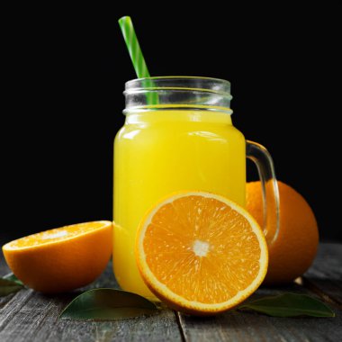 Koyu ahşap arka planda taze soğuk portakal suyu.