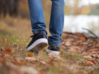 Sonbahar Parkı 'nda ya da ormanda şık siyah ayakkabılar giyen erkeklerin ayakları. Mevsimlik ayakkabılar