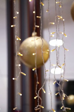 LED çelenklerle çevrili Altın Noel ağacı topu.