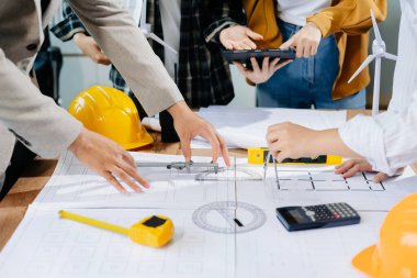 Modern ofisteki inşaat sahasında mimari projeyle büyük çizimlere yansıyan yaratıcı mimar