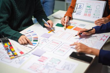 UI müteahhitlerinin projelerini dizüstü bilgisayar, akıllı telefon ve dijital tablet ile beyin fırtınası yaparken görüntülerini kapatın. Yaratıcı dijital geliştirme ajansı.