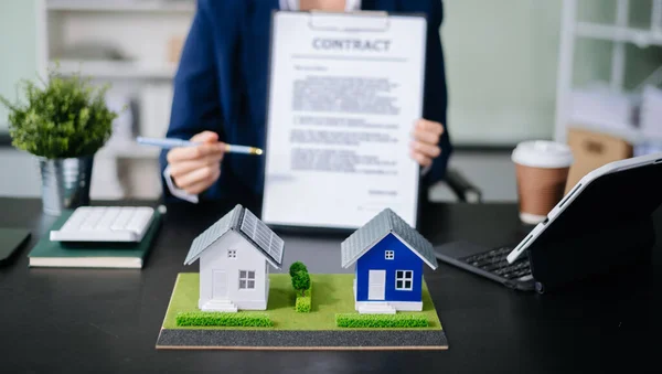 Emlak sektörünü dengelemek için emlakçı ev tasarımını ve satın alma anlaşmasını görmek için ev tarzını açıklıyor. Ofiste model ev ve komdo.