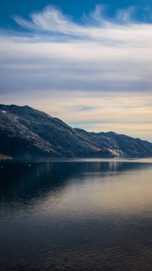Sarp dağlar ve buzullar Prins 'in sakin sularına yansıdı Christian Sund, Güney Grönland, Ağustos 2025