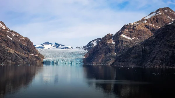 Sarp dağlar ve buzullar Prins 'in sakin sularına yansıdı Christian Sund, Güney Grönland, Ağustos 2025