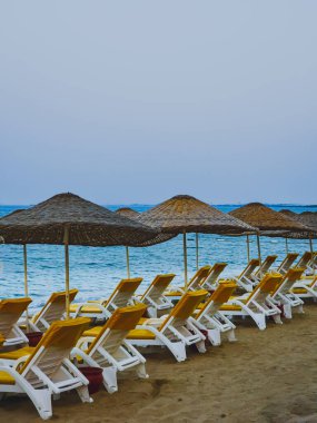 Akdeniz kıyısındaki güneş pansiyonları ve plaj şemsiyeleri, Kıbrıs, yaz tatili sahnesi