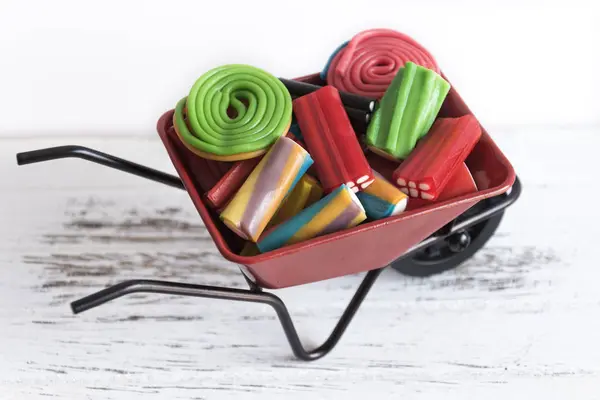 Kırmızı el arabası tam goodies beyaz arka plan üzerinde farklı tatlar.