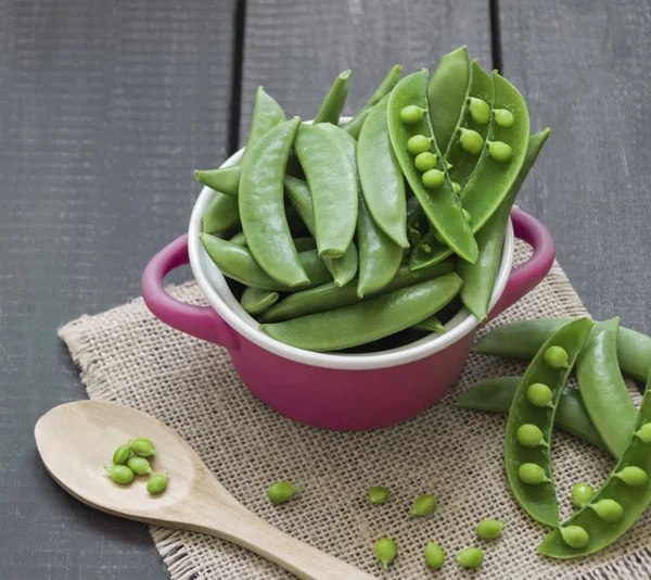 Pods bezelye bezelye tahta kaşıkla ve küçük bir masa örtüsü ile bir tencerede çuval bezi kumaştan yapılmış.