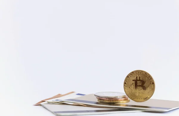 Bir avuç bitcoin bozukluk, beyaz bir arka plan üzerinde iki banka kitap üstünde. Yatay biçimde.