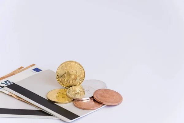 Bir avuç bitcoins banka kitapçıklar ve iki euro banknot, beyaz bir arka plan üzerinde izole. Yatay biçimde.