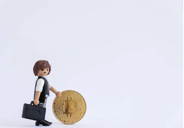 Küçük bebek beyaz arka plan üzerinde izole bir bitcoin tutan evrak çantası ile. Yatay biçimde.