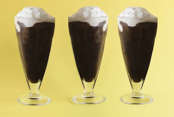 Gözlüklü sarı zemin üzerine kahve ile üç kremalı dondurmalar slush. Yatay biçimde.