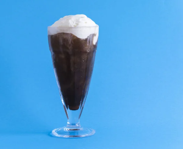 Bir bardak kahve rüşvet mavi bir arka plan üzerinde olan dondurma ile. Yatay biçimde.