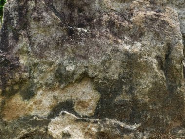 Eskimiş bir kaya yüzeyinin soyut görüntüsü, eşsiz bir doku ve kahverengi ve gri tonların karışımı..