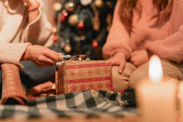 Bir anne ve kızı kanepede oturup iç açıcı bir anı paylaşıyorlar. Bu resim zanaat, aile birliği, öğrenme ve evin rahatlığını temsil ediyor..