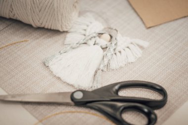 Makrome projesi, makas ve pamuk ipiyle dolu bir hayat. Yaratıcı hobileri, DIY projelerini ya da ev dekorunu göstermek için mükemmel. Nötr renk paleti ve yumuşak ışıklandırma.