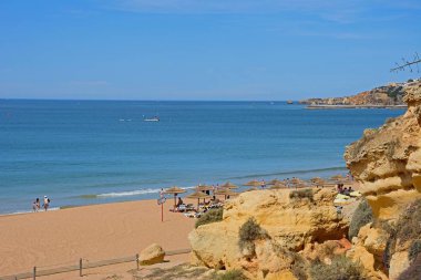 Albufeira, Portekiz - 10 Haziran 2017 - turist rahatlatıcı görünümünü manzaralı sahilde deniz ve ön planda, Albufeira, Portekiz, Avrupa, 11 Haziran 2017 büyük kayalar yükseltilmiş.