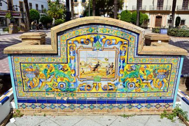Plaza de la Laguna, Ayamonte, Huelva ilinde, Endülüs, İspanya, Avrupa, 11 Haziran 2017 geleneksel İspanyol sahnede ile seramik bir Bank arkası Ayamonte, İspanya - 11 Haziran 2017-.