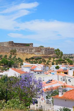 Castro Marim, Portekiz - 11 Haziran 2017 - 11 Haziran 2017 görünümü binaların kale ve şehir güzel bir jakaranda ağacı ön planda, tam Bloom ile Castro Marim, Algarve, Portekiz, Avrupa, yüksek.