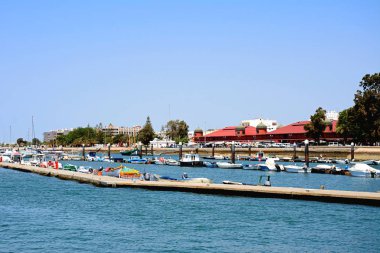 12 Haziran 2017 mesire (Avenida 5 de Outubro) ve sağ tarafında, Olhau, Algarve, Portekiz, Avrupa'ya kapalı çarşı binaları ile Marina Olhau, Portekiz - 12 Haziran 2017 - görünümünü tekneler ve yatlar demirli.