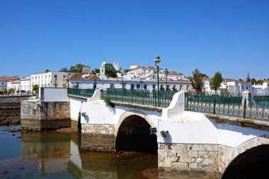 Roma Köprüsü (Ponte Romano) ve Gilao Nehri şehir binaları arka, Tavira, Algarve, Portekiz, Avrupa ile görünüm.