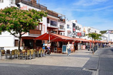 Albufeira, Portekiz - 10 Haziran 2017 - kaldırım kafeleri Av 25 de Abril Albufeira, Algarve, Portekiz, Avrupa tarafından 10 Haziran 2017 geçen turistler ile eski şehir boyunca.